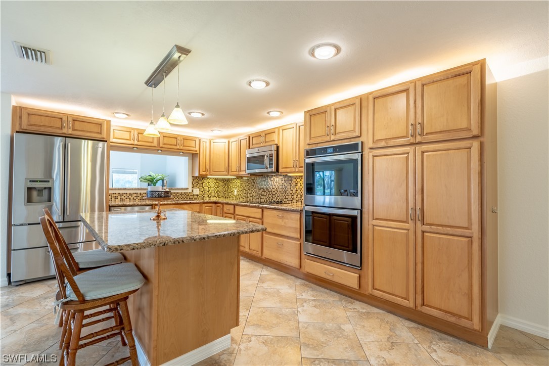 109 Audubon Road Naples, FL 34114 - Photo 5 of 41 a kitchen with stainless steel appliances granite countertop a refrigerator and a stove top oven