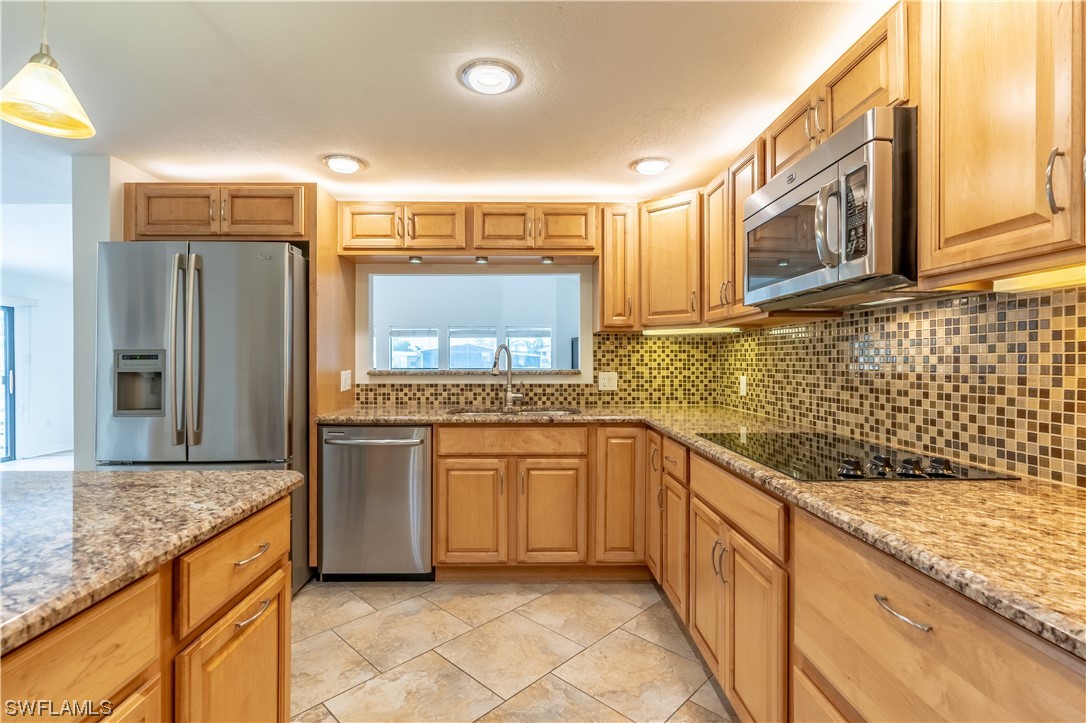 109 Audubon Road Naples, FL 34114 - Photo 6 of 41 a kitchen with stainless steel appliances granite countertop a sink stove and refrigerator
