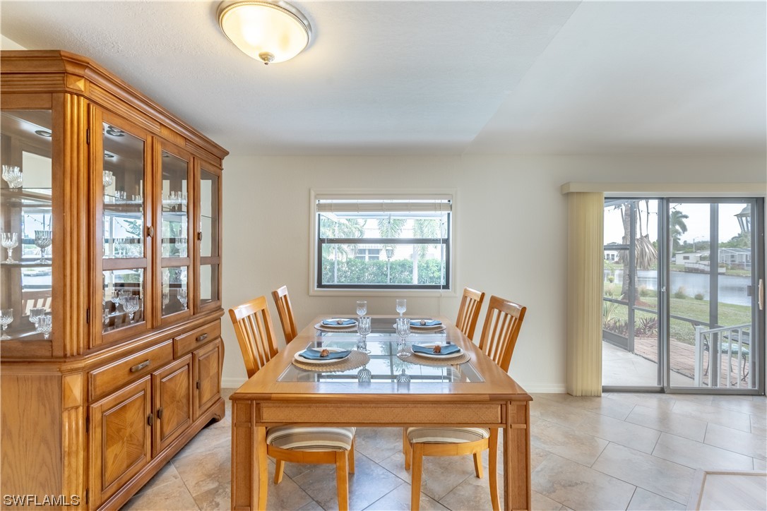 109 Audubon Road Naples, FL 34114 - Photo 8 of 41 a view of a dining room with furniture a livingroom and chandelier