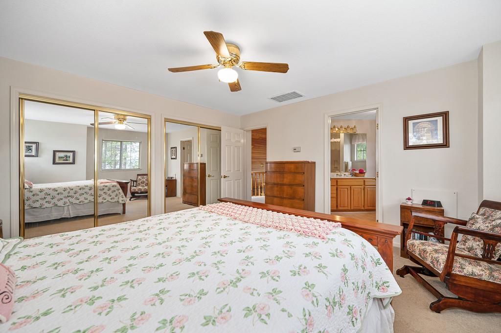 2358 Deer Ravine Court Cool, CA 95614 - Photo 23 of 63 bedroom with multiple closets, a ceiling fan, light colored carpet, and connected bathroom