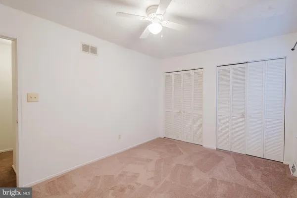 a view of an empty room with a ceiling fan