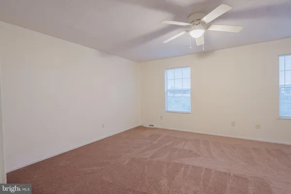 an empty room with a chandelier fan