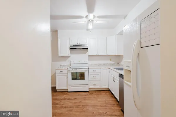 a kitchen with white cabinets and white appliances