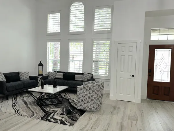 a living room with furniture and two window
