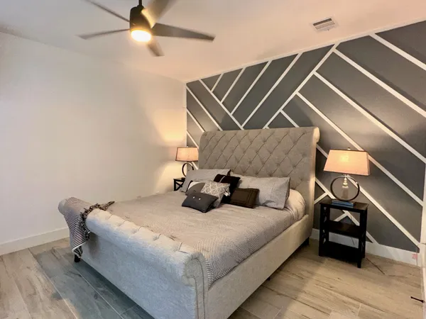 a bedroom with a bed and wooden floor