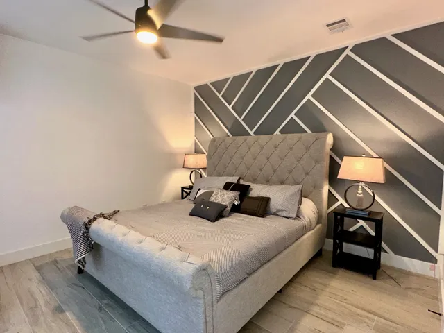 a bedroom with a bed and wooden floor