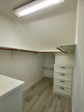 a view of walk in closet with empty racks