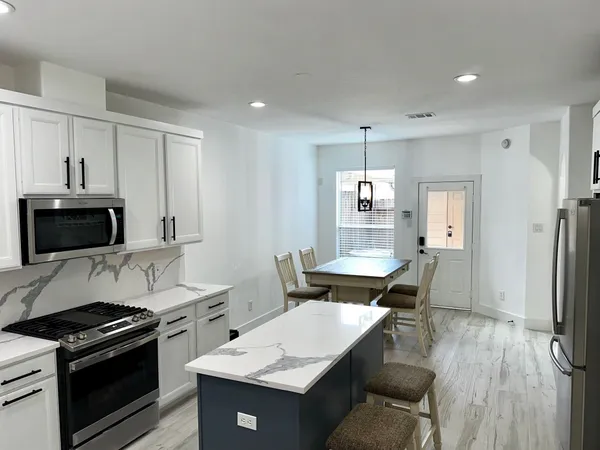 a kitchen with a stove a sink and a refrigerator