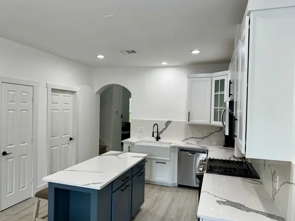 a kitchen with a sink refrigerator and cabinets