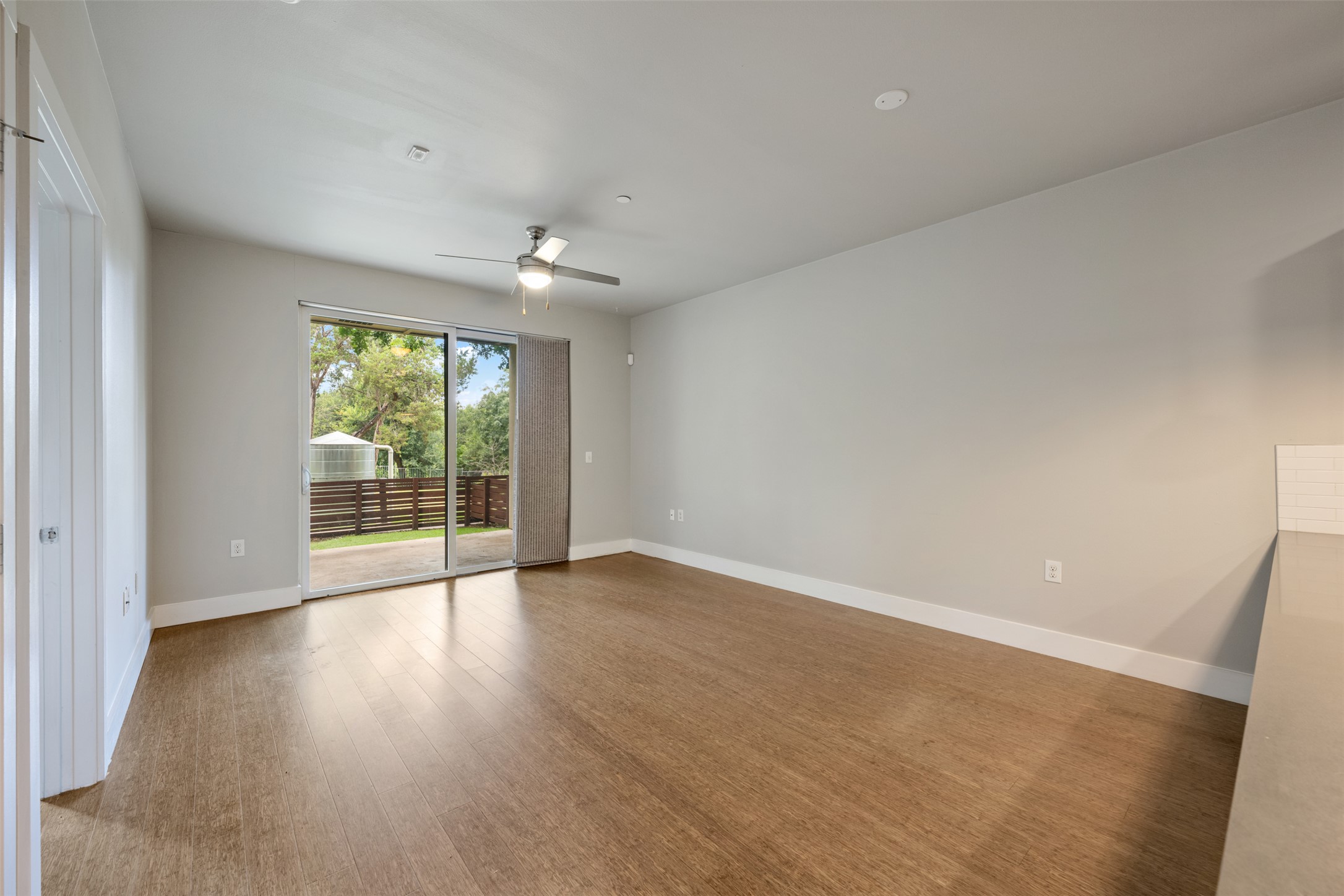 2804 Treble Lane, Unit 902 Austin, TX 78704 - Photo 13 of 31 a view of an empty room with wooden floor and a window