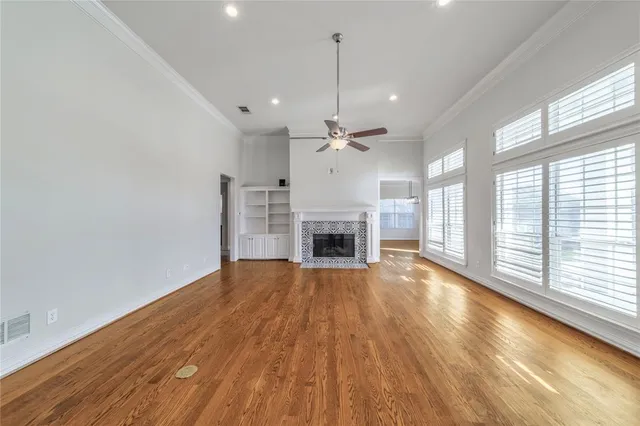 a view of a livingroom with wooden floor fireplace and windows