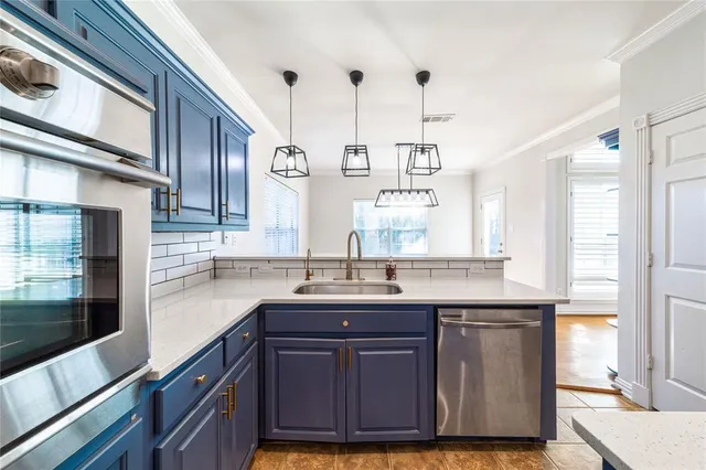 a kitchen with stainless steel appliances granite countertop a sink a window and wooden cabinets