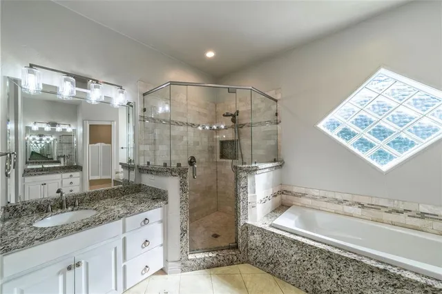 a bathroom with a granite countertop sink mirror bathtub and shower