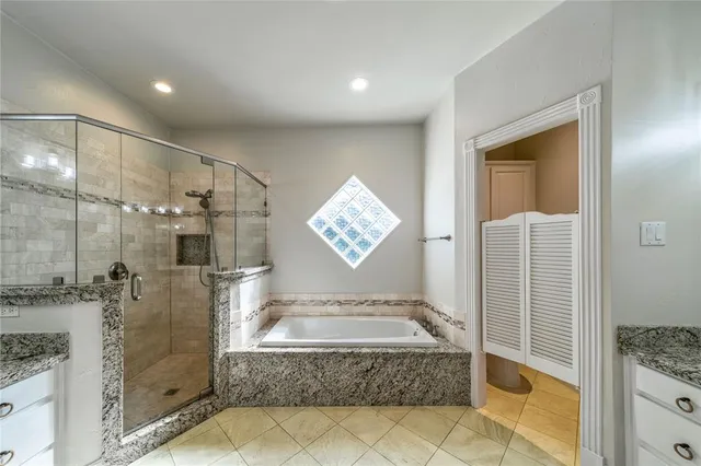 a bathroom with a granite countertop sink a mirror and shower