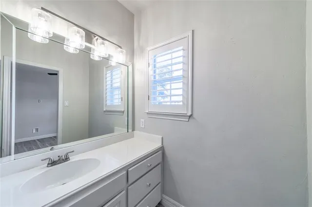 a bathroom with a sink vanity granite and a mirror