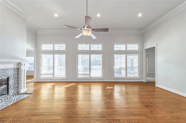 an empty room with wooden floor and chandelier fan