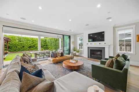 a living room with furniture a fireplace and a large window