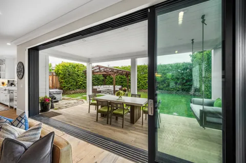 a dining room with wooden floor glass table and chairs