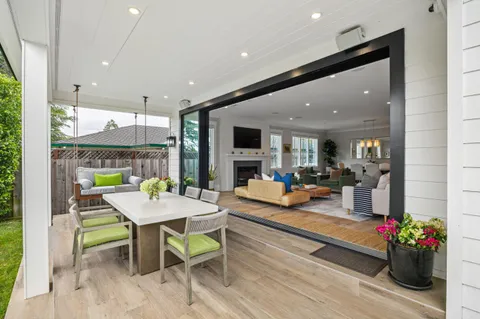 a view of a dining room with furniture one side kitchen view and wooden floor