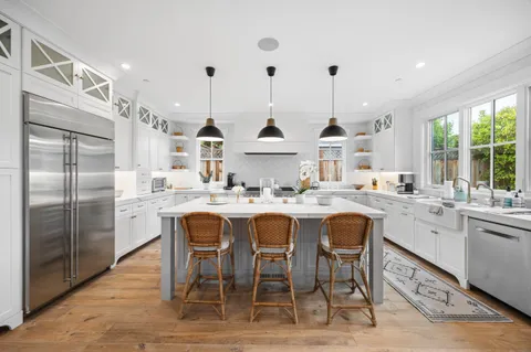 a kitchen with kitchen island granite countertop a sink and refrigerator