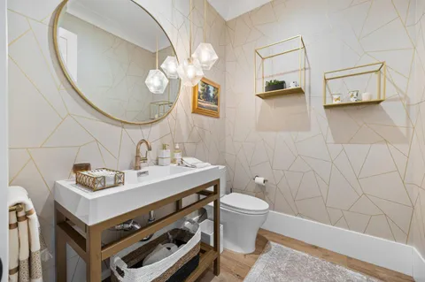 a bathroom with a sink a toilet and a mirror