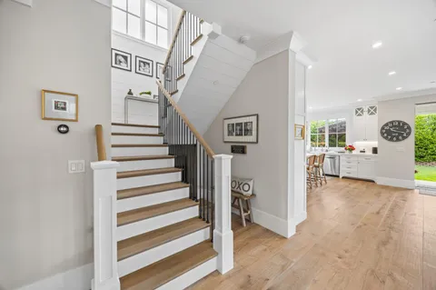 a view of a livingroom with wooden floor and stairs