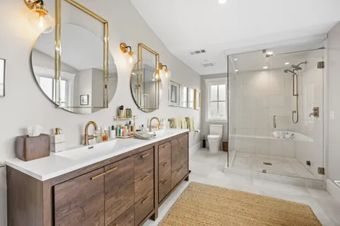 a bathroom with a sink double vanity granite tub and a mirror