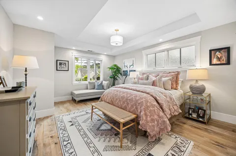 a spacious bedroom with a bed a table and painting on the wall