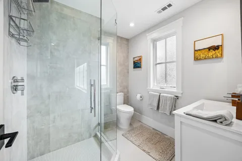 a bathroom with a granite countertop sink toilet and shower