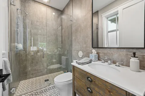 a bathroom with a sink a toilet and shower