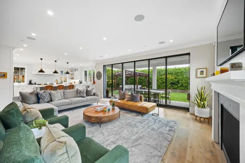 a living room with fireplace furniture and a large window