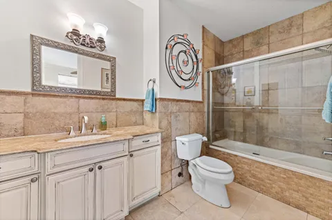 a bathroom with a granite countertop sink mirror toilet and bathtub