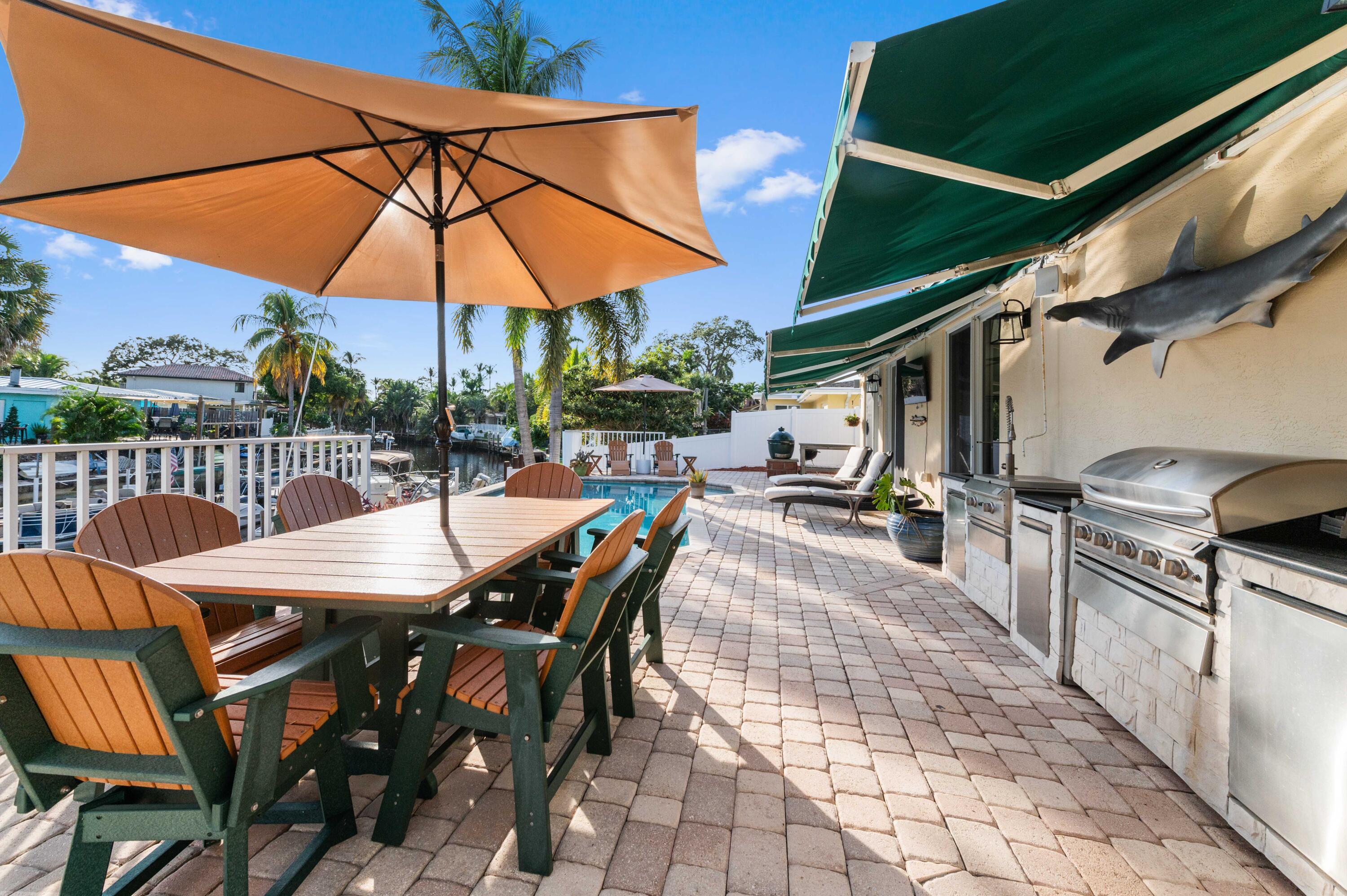 746 West Palmetto Park Road Boca Raton, FL 33486 - Photo 44 of 60 a view of a patio with a table and chairs under an umbrella