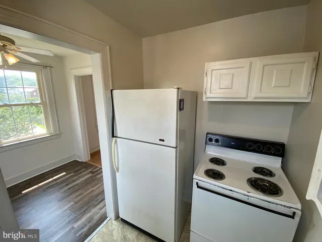 a white refrigerator freezer and a stove sitting inside of a kitchen