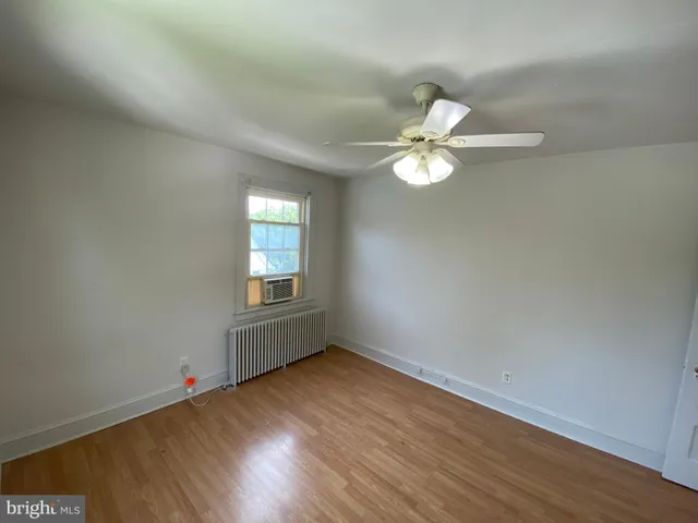 an empty room with wooden floor and window