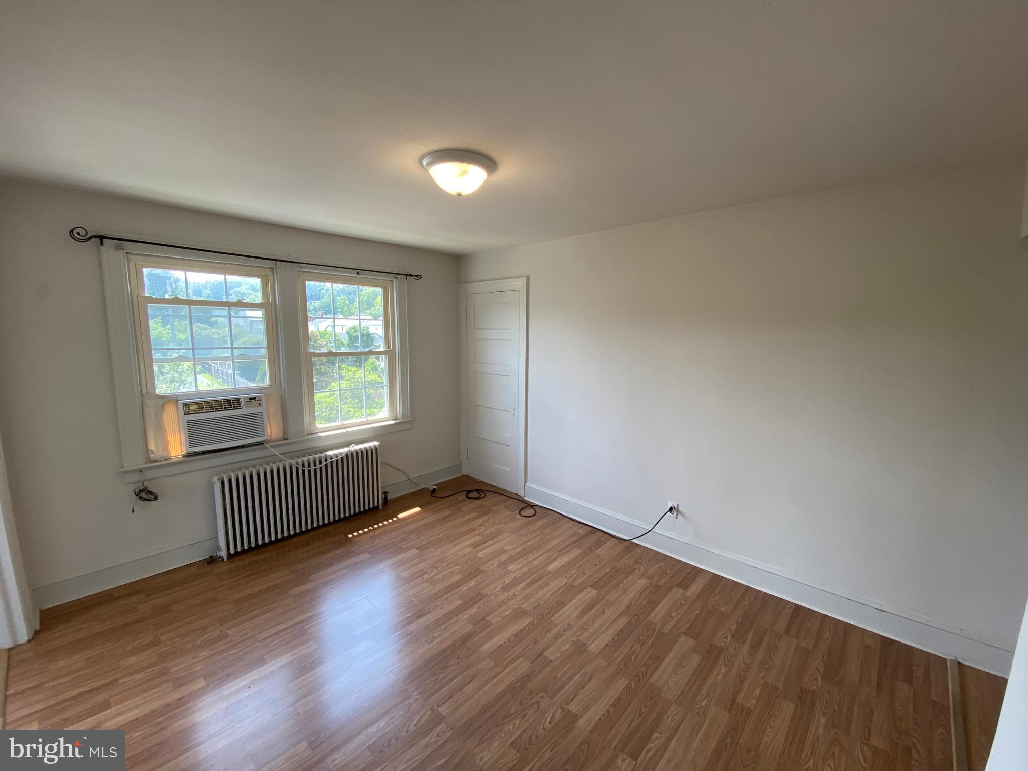1003 Kenmore Avenue, Unit 3 Fredericksburg, VA 22401 - Photo 5 of 16 an empty room with wooden floor and windows