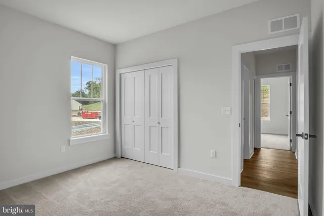 an empty room with windows and closet