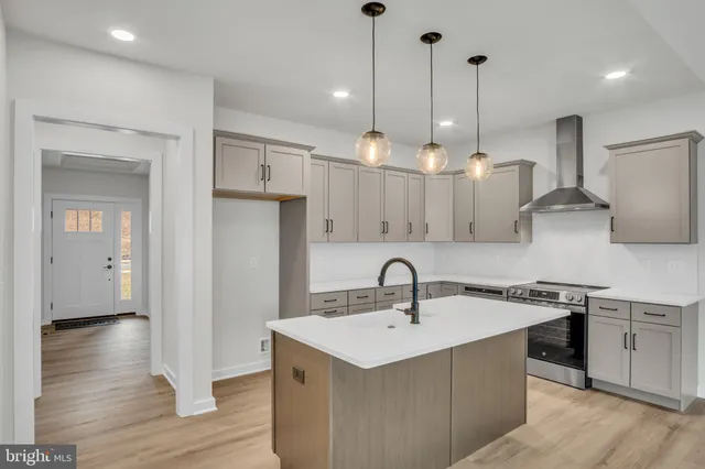 a kitchen with kitchen island a sink stainless steel appliances and cabinets