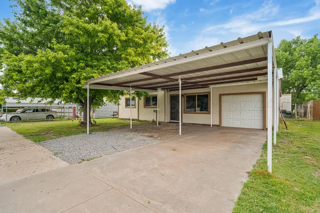 a view of a house with a backyard and a large tree