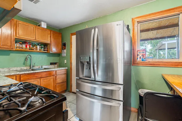 a kitchen with stainless steel appliances granite countertop a refrigerator and a stove top oven