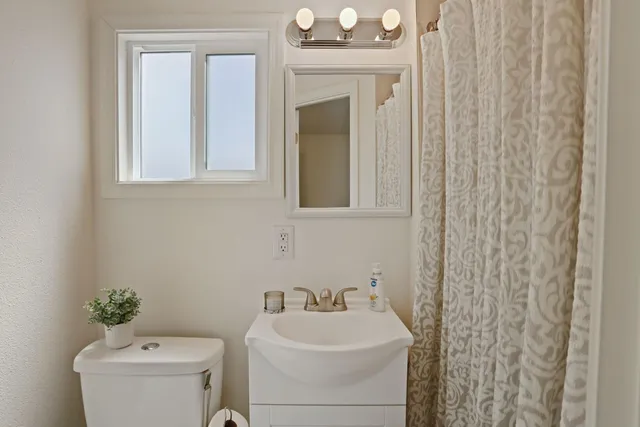 a bathroom with a sink a toilet and mirror