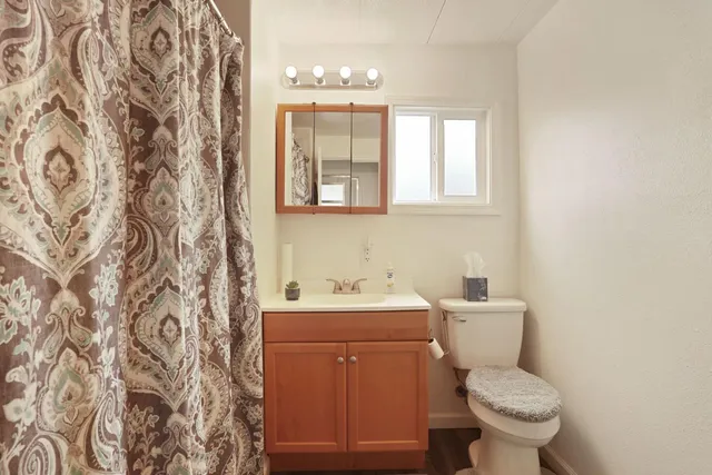 a bathroom with a toilet sink and mirror