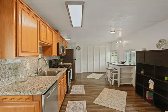 a kitchen with stainless steel appliances granite countertop a sink stove and cabinets