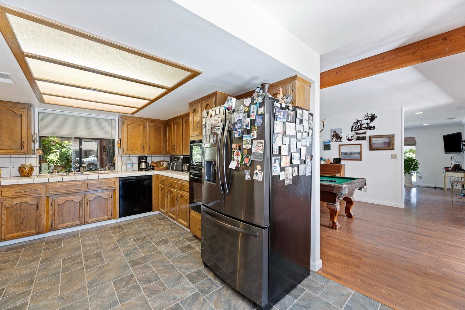 305 Monroe Street Coalinga, CA 93210 - Photo 21 of 53 a kitchen with stainless steel appliances granite countertop a refrigerator a sink dishwasher and a stove with wooden floor
