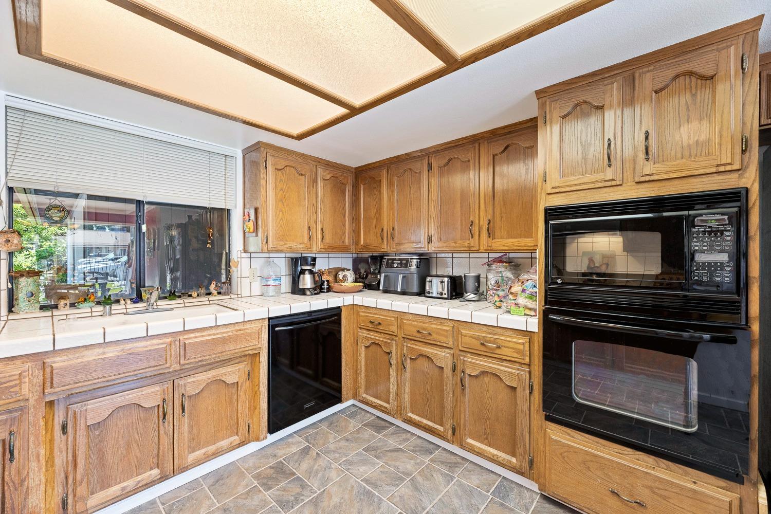 305 Monroe Street Coalinga, CA 93210 - Photo 26 of 53 a kitchen with cabinets stainless steel appliances and a window