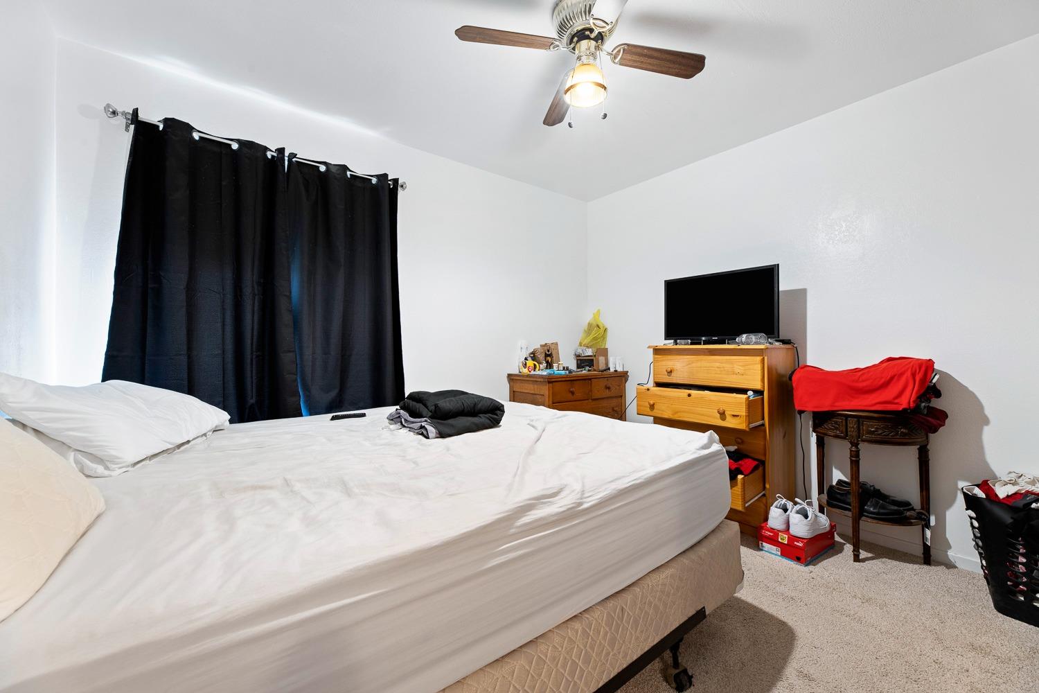 305 Monroe Street Coalinga, CA 93210 - Photo 29 of 53 a bedroom with a bed and a flat tv screen on dresser