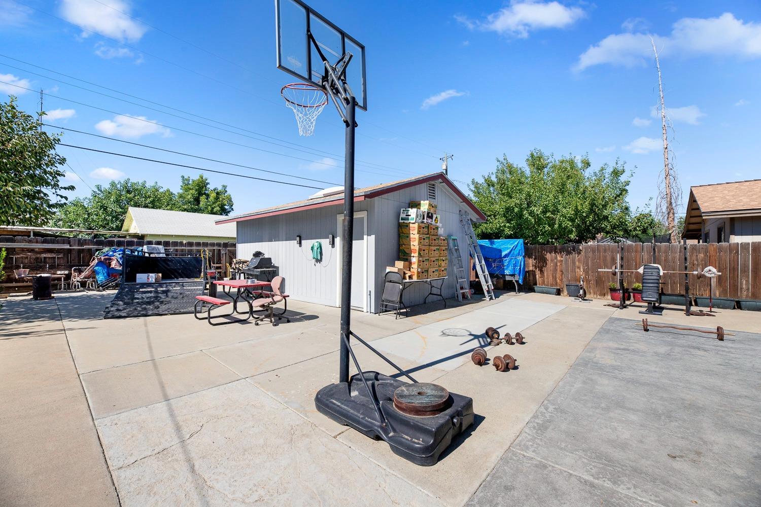 305 Monroe Street Coalinga, CA 93210 - Photo 39 of 53 a view of a patio with table and chairs potted plants with wooden fence