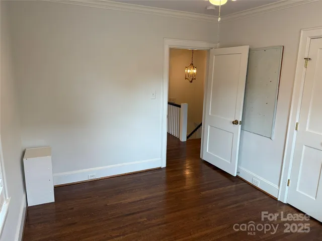an empty room with wooden floor and mirror