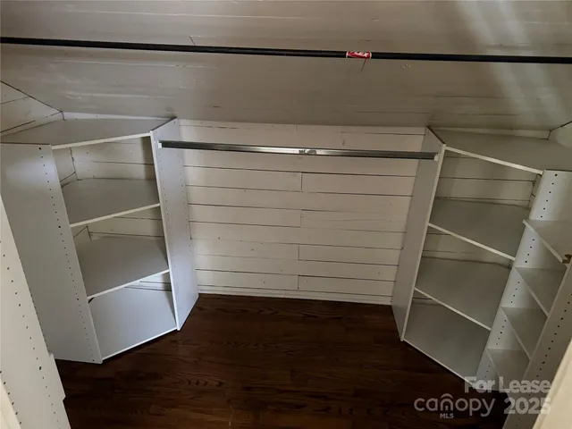 a view of walk in closet with empty racks