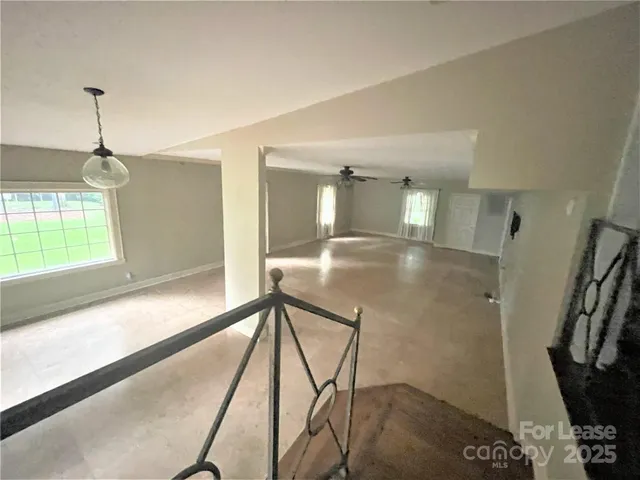 a view of a hallway with furniture and floor to ceiling window